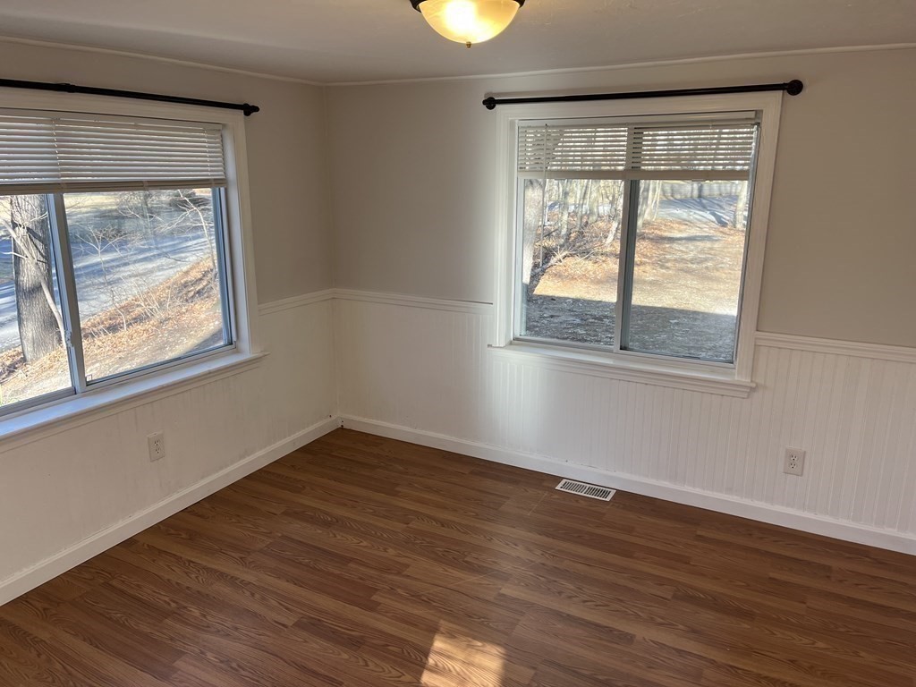 49 Hayden Pond Road, Unit 2 Dudley, MA 01571 - Photo 11 of 18 a view of an empty room with wooden floor and windows