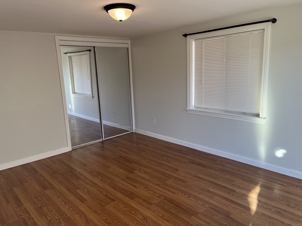 49 Hayden Pond Road, Unit 2 Dudley, MA 01571 - Photo 12 of 18 an empty room with wooden floor and windows