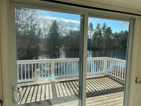 a view of a wooden balcony with a yard
