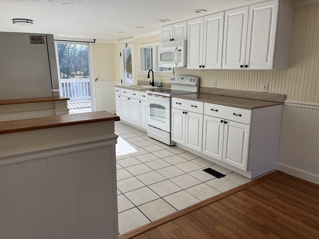 49 Hayden Pond Road, Unit 2 Dudley, MA 01571 - Photo 8 of 18 a kitchen with stainless steel appliances a sink stove and cabinets