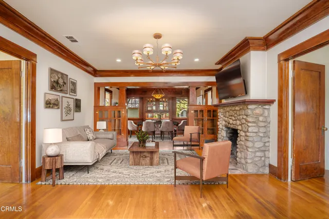 a hallway with wooden floor and livingroom with furniture