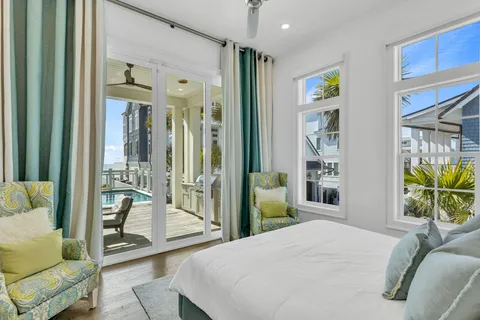 a bedroom with a large bed and windows