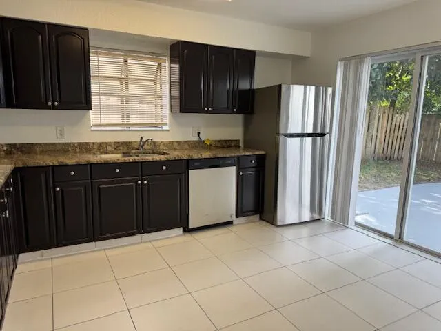 a kitchen with granite countertop a refrigerator and a sink
