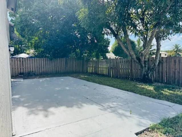 a view of a yard with wooden fence and trees