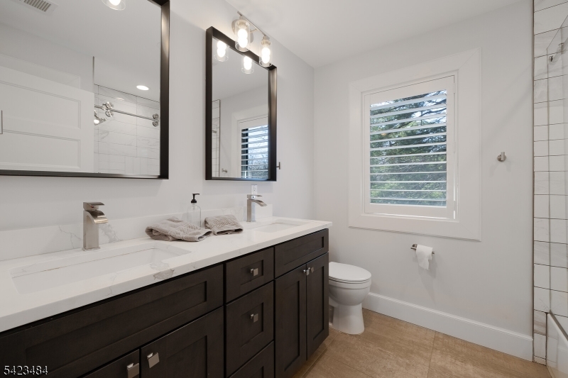 57 Walnut Street Livingston, NJ 07039 - Photo 30 of 43 a bathroom with a granite countertop sink a toilet a and a mirror