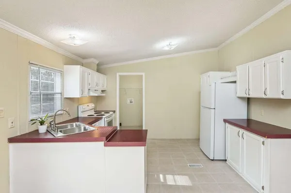 a living room with furniture a window and a refrigerator