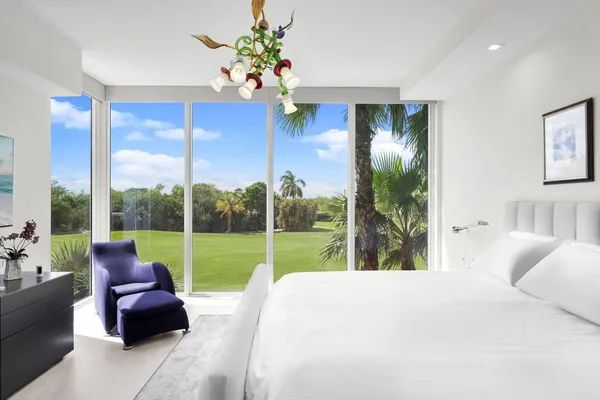 a bed sitting in a bedroom next to a large window with yard