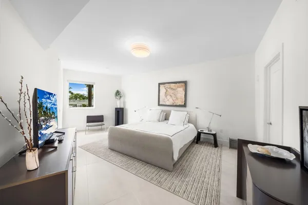 a bedroom with a bed and a flat screen tv