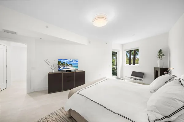 a bedroom with a large bed and a chandelier