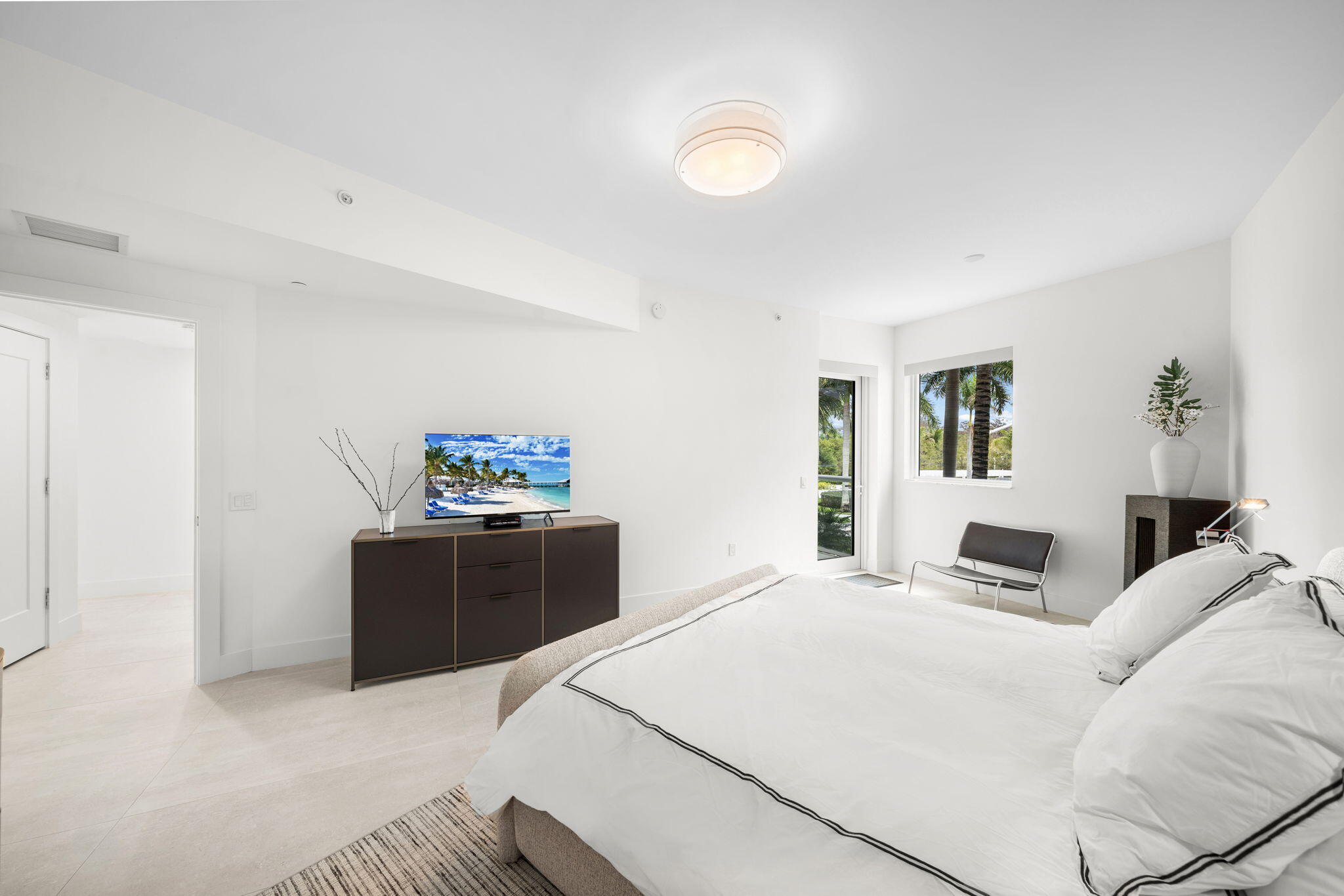 20155 Boca W Drive, Unit C201 Boca Raton, FL 33434 - Photo 16 of 42 a bedroom with a large bed and a chandelier