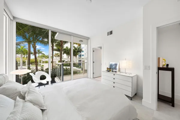 a bedroom with a bed and large window