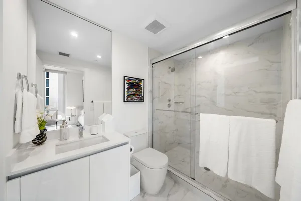 a bathroom with a sink a toilet and shower