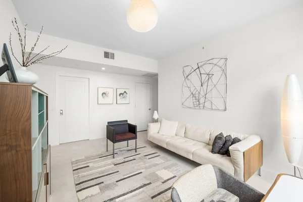 a living room with furniture and a painting on the wall