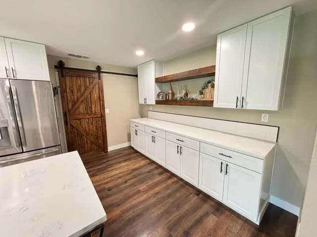 a kitchen with white cabinets and refrigerator