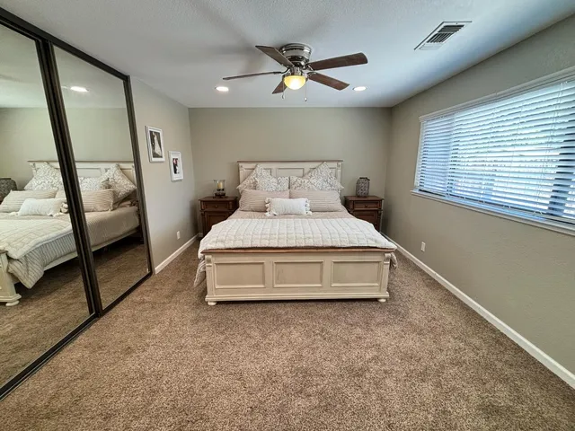 a spacious bedroom with a bed and a large window