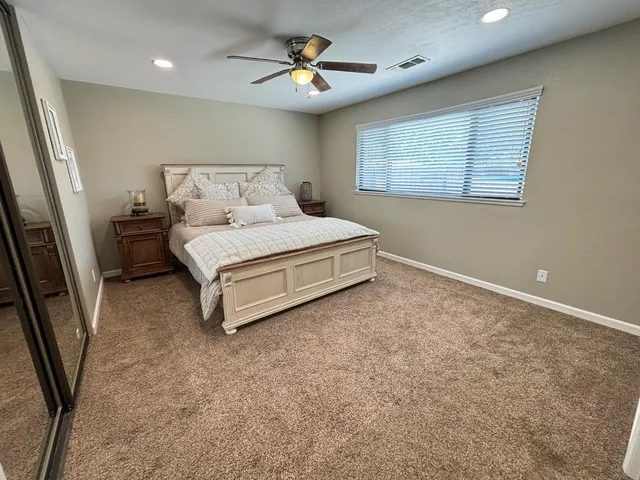 a spacious bedroom with a bed and a chandelier