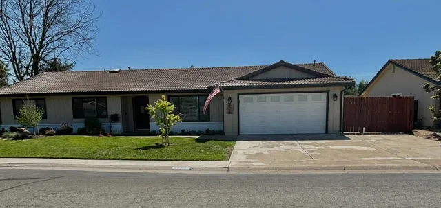 a front view of a house with a garden and plants