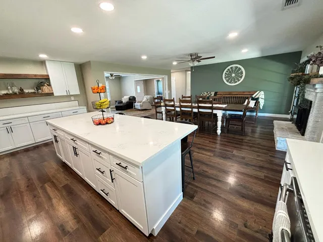 a kitchen with stainless steel appliances granite countertop a stove and a wooden floors
