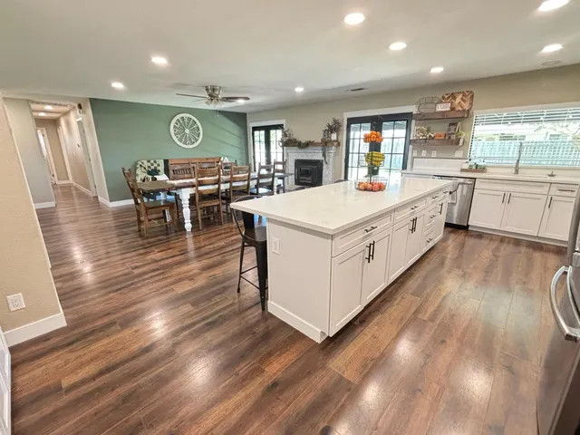 a large kitchen with stainless steel appliances a lot of counter space and a wooden floors