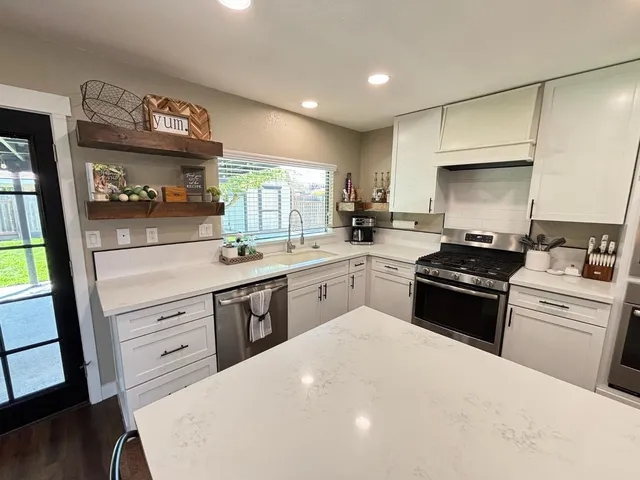 a kitchen with a sink a stove and cabinets