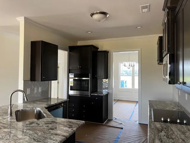 a kitchen with stainless steel appliances granite countertop a refrigerator and a sink