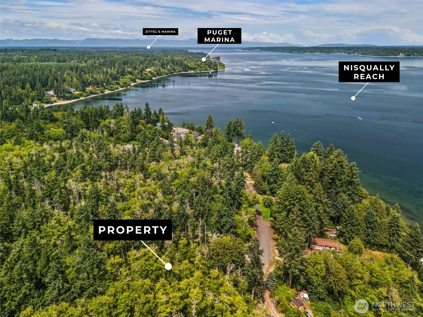 7605 Sandy Point Road Northeast Olympia, WA 98516 - Photo 4 of 25 a view of a street with potted plants and brick wall