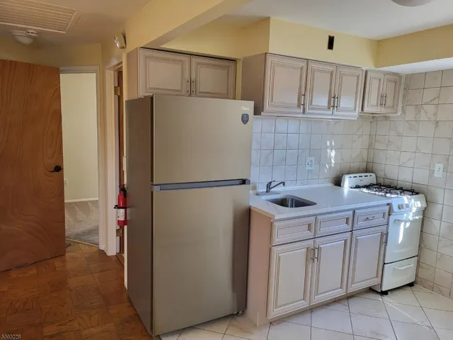 a kitchen with a refrigerator sink stove and cabinets