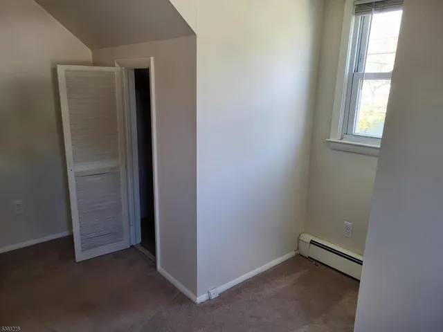 an empty room with windows and closet