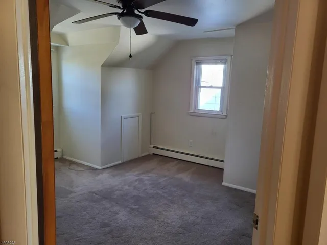 an empty room with a window and a fan