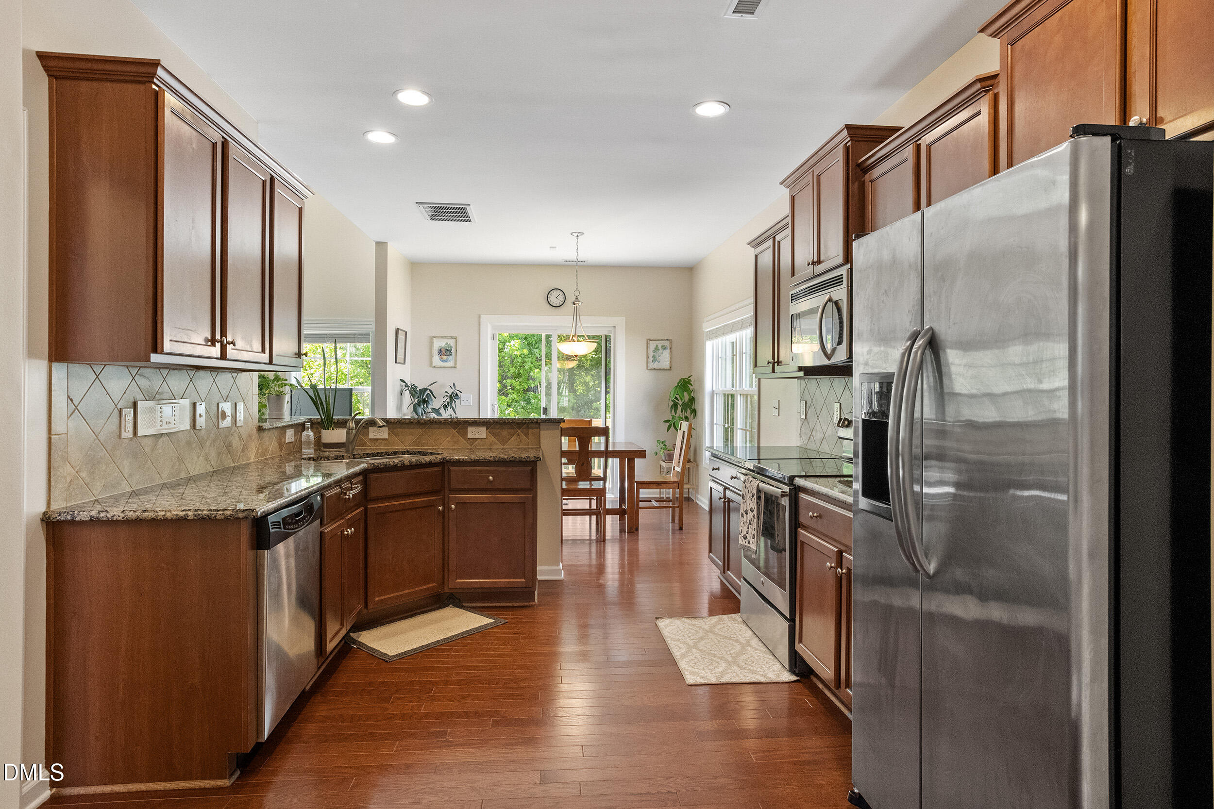 235 Strolling Way Durham, NC 27707 - Photo 11 of 32 a kitchen with stainless steel appliances granite countertop a refrigerator a stove a sink and a microwave