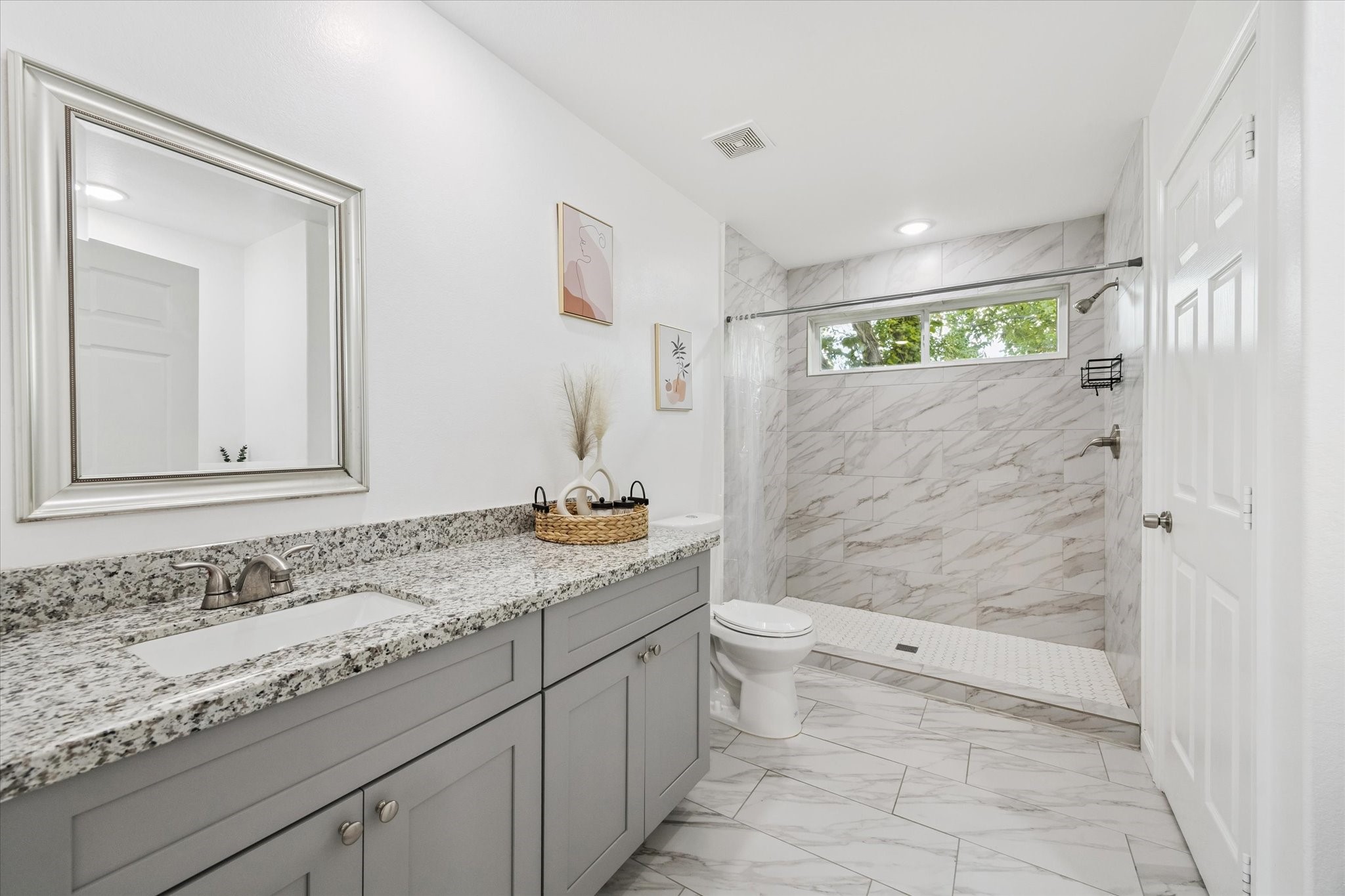 2631 Stevens Street Houston, TX 77026 - Photo 18 of 25 One of two dedicated vanities in the primary ensuite, offering ample storage, a wide granite countertop, and an undermount sink—perfect for everyday function and personal space.