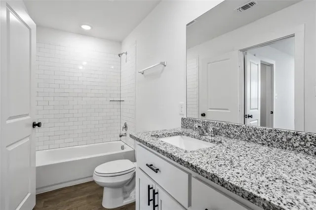 a bathroom with a granite countertop sink toilet and shower