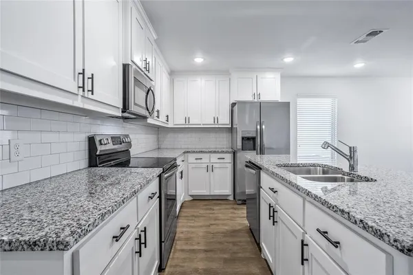 a kitchen with stainless steel appliances granite countertop a sink stove and refrigerator