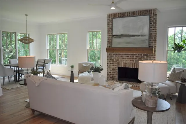 a living room with furniture a fireplace and a floor to ceiling window