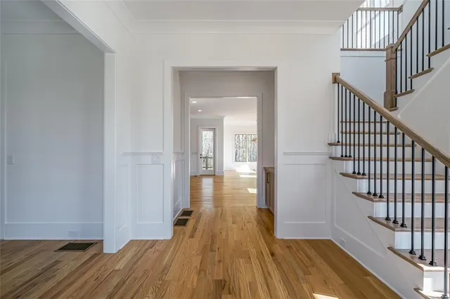 a view of a hallway with wooden floor and staircase
