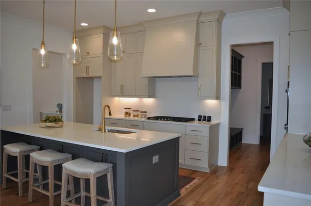 a kitchen with a sink cabinets and wooden floor