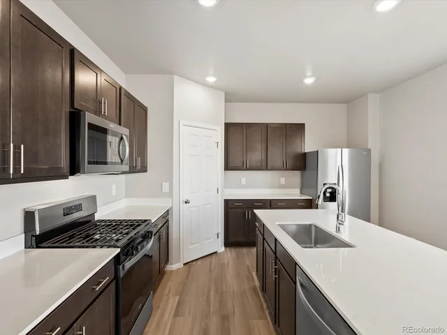 a kitchen with stainless steel appliances granite countertop a sink stove and refrigerator