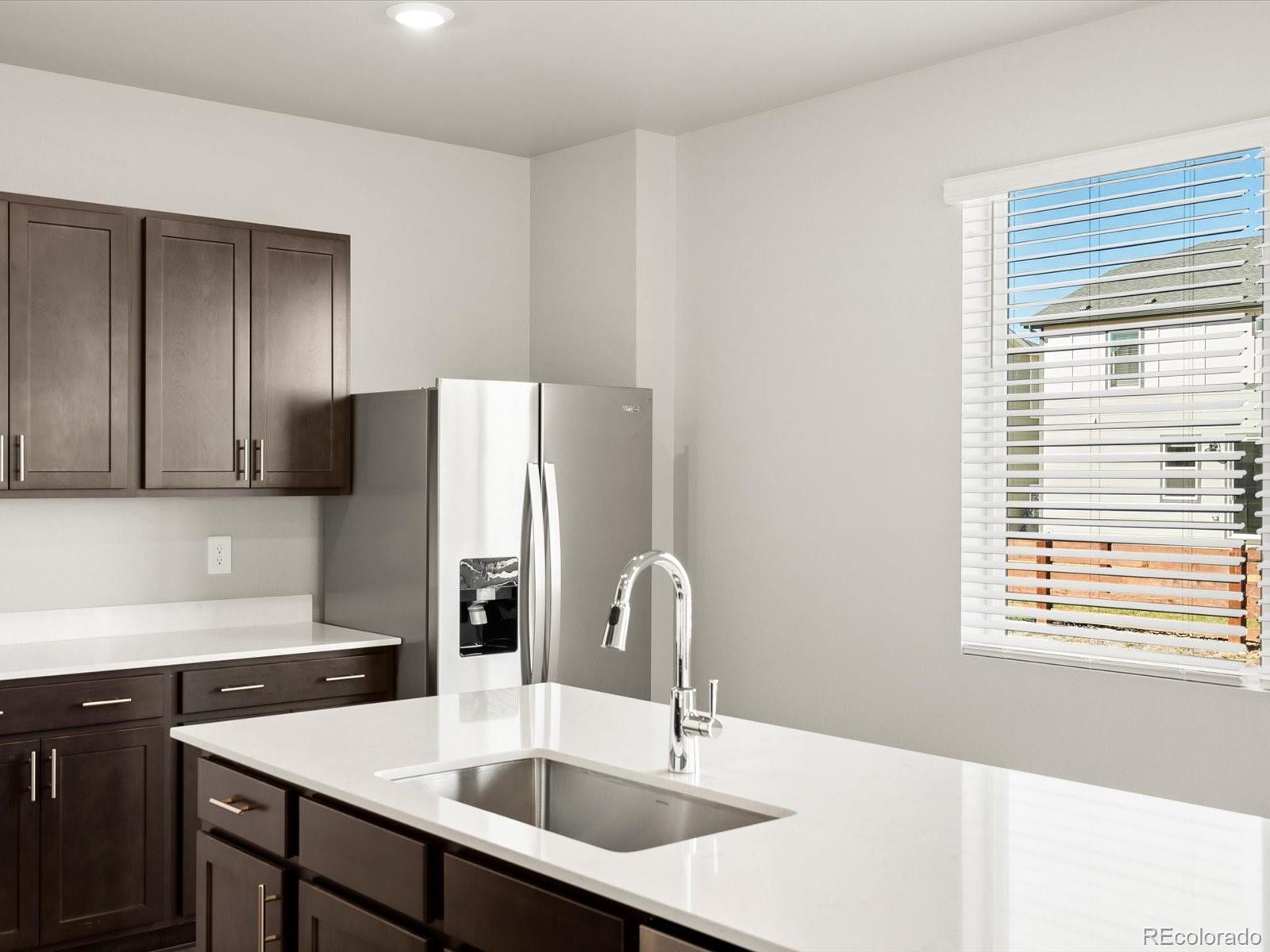 4673 Rabbitbrush Street Johnstown, CO 80534 - Photo 12 of 31 a kitchen with a sink a refrigerator and a window