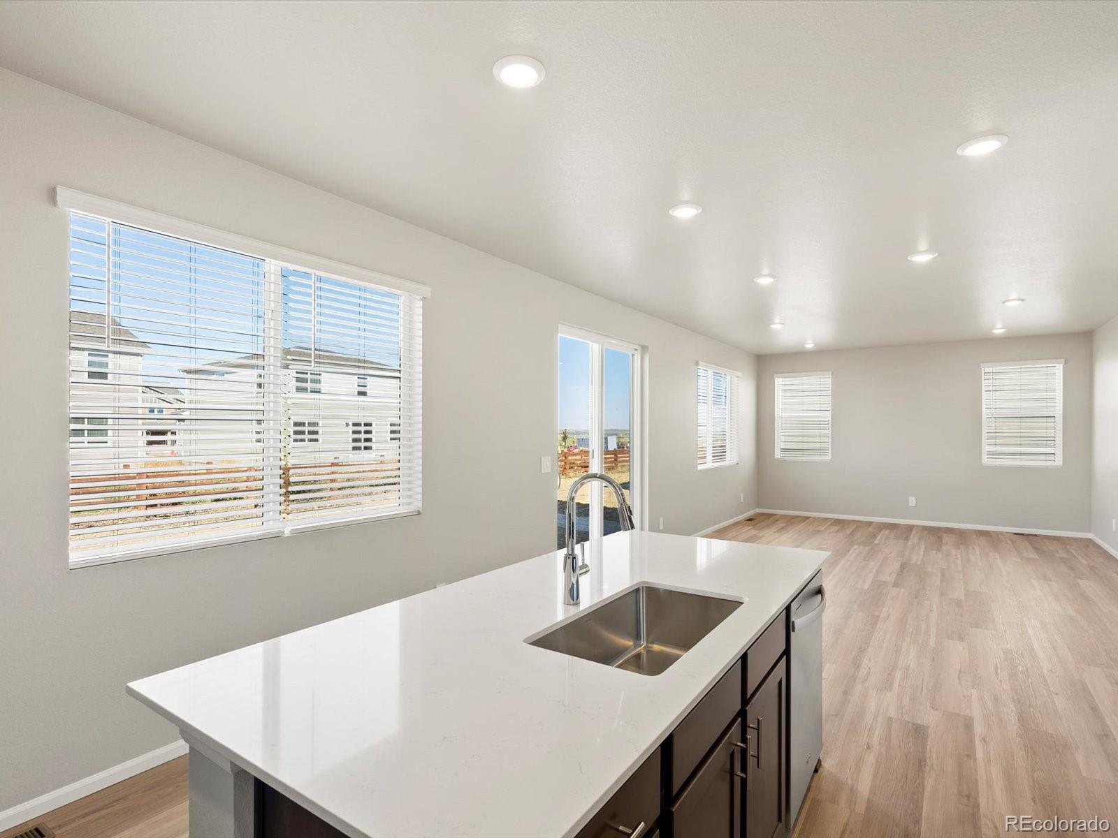 4673 Rabbitbrush Street Johnstown, CO 80534 - Photo 14 of 31 a kitchen with center island wooden floor and center island