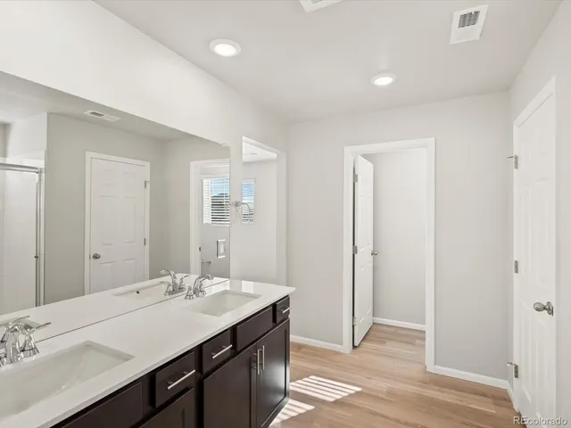 a bathroom with a double vanity sink and a mirror