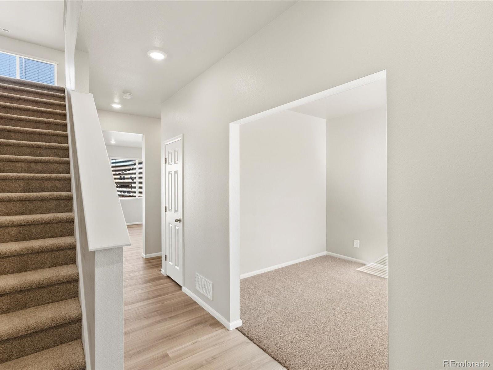 4673 Rabbitbrush Street Johnstown, CO 80534 - Photo 3 of 31 a view of a hallway with wooden floor and staircase