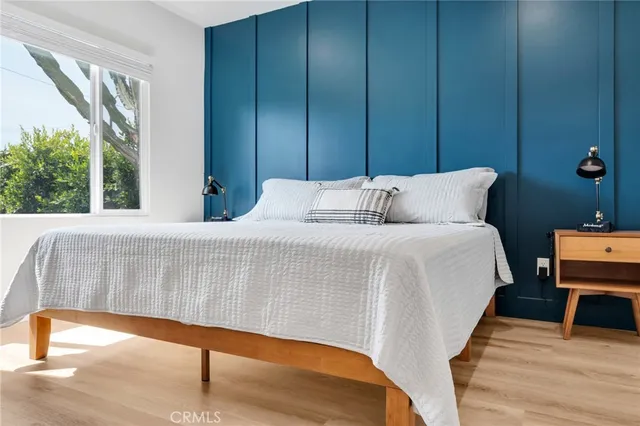 a bedroom with a large bed and a wooden floor