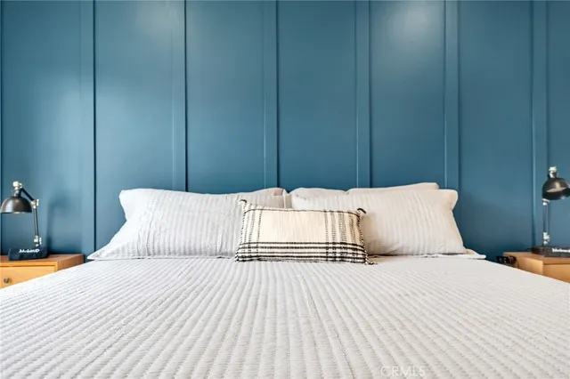 a bedroom with a bed a flat screen tv and a large mirror