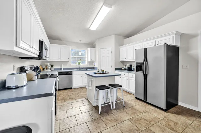 a kitchen with stainless steel appliances granite countertop a refrigerator sink and cabinets