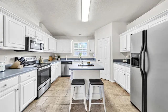a kitchen with a sink stove cabinets and refrigerator