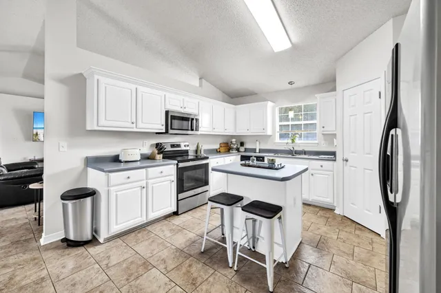 a kitchen with cabinets stainless steel appliances and a window