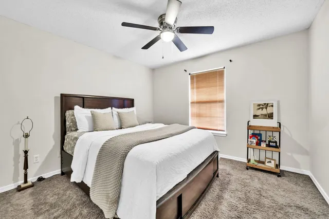 a bed room with a bed and a ceiling fan
