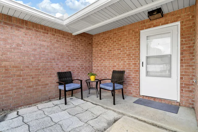 a brick building with a bench and a chair