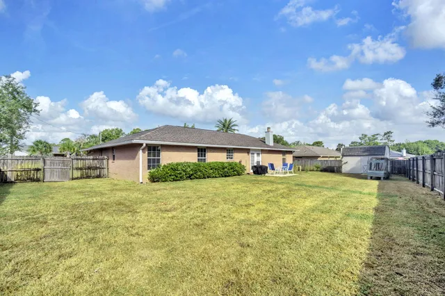 a view of a big house with a big yard and potted plants