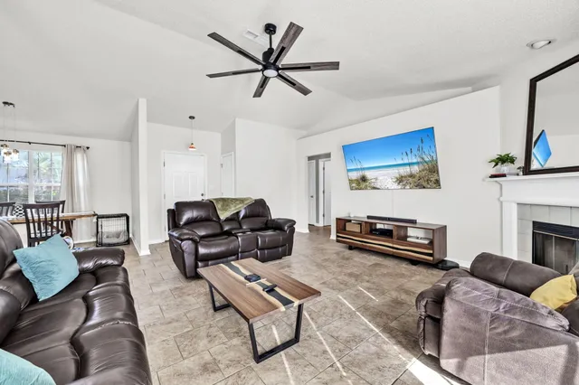 a living room with furniture a fireplace and a flat screen tv